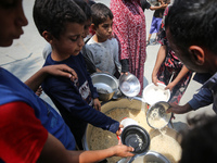 Palestinians are gathering to receive food meals cooked by World Central Kitchen (WCK) after the charity resumed operations at a school shel...