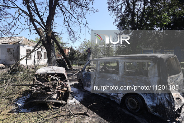 Burnt-out cars are being seen in the street following a Russian strike on Zolochiv in the Kharkiv region, northeastern Ukraine, with guided...