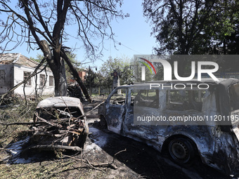 Burnt-out cars are being seen in the street following a Russian strike on Zolochiv in the Kharkiv region, northeastern Ukraine, with guided...