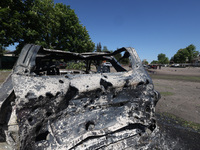 A burnt-out car is being seen in the street following a Russian strike on Zolochiv in the Kharkiv region, northeastern Ukraine, with guided...