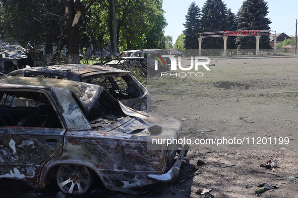 Burnt-out cars are being seen in the street following a Russian strike on Zolochiv in the Kharkiv region, northeastern Ukraine, with guided...