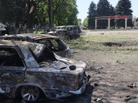 Burnt-out cars are being seen in the street following a Russian strike on Zolochiv in the Kharkiv region, northeastern Ukraine, with guided...