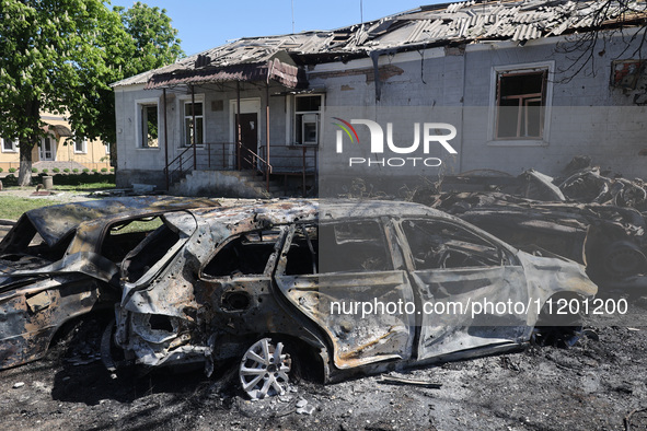 Burnt-out cars are being seen in the street following a Russian strike on Zolochiv in the Kharkiv region, northeastern Ukraine, with guided...