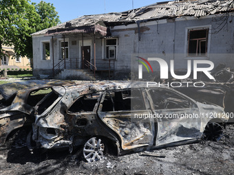 Burnt-out cars are being seen in the street following a Russian strike on Zolochiv in the Kharkiv region, northeastern Ukraine, with guided...