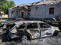 Burnt-out cars are being seen in the street following a Russian strike on Zolochiv in the Kharkiv region, northeastern Ukraine, with guided...