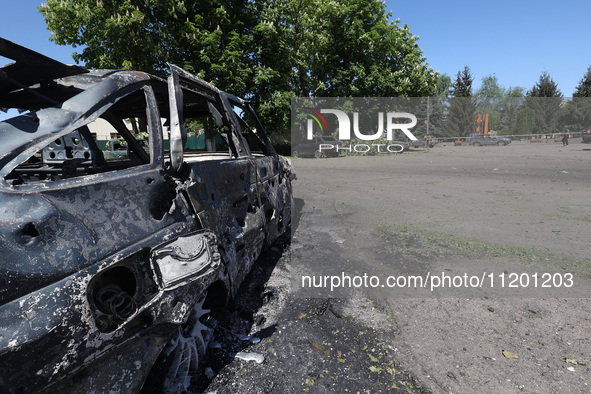 A burnt-out car is being seen in the street following a Russian strike on Zolochiv in the Kharkiv region, northeastern Ukraine, with guided...