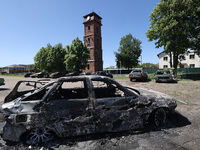 A burnt-out car is being seen in the street following a Russian strike on Zolochiv in the Kharkiv region, northeastern Ukraine, with guided...