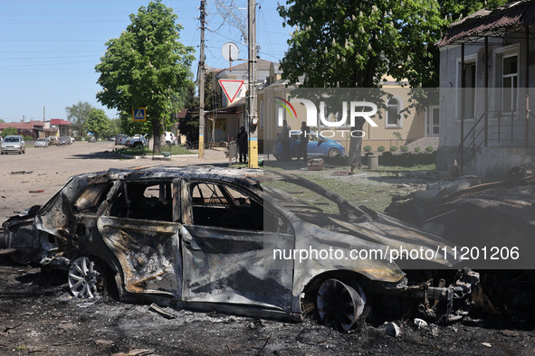 A burnt-out car is being seen in the street following a Russian strike on Zolochiv in the Kharkiv region, northeastern Ukraine, with guided...