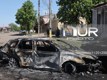 A burnt-out car is being seen in the street following a Russian strike on Zolochiv in the Kharkiv region, northeastern Ukraine, with guided...