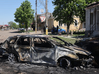 A burnt-out car is being seen in the street following a Russian strike on Zolochiv in the Kharkiv region, northeastern Ukraine, with guided...