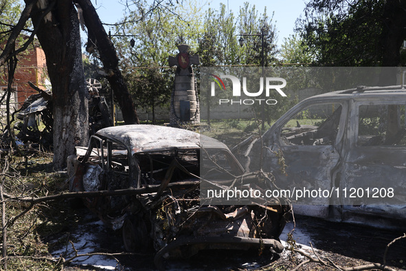 Burnt-out cars are being seen in the street following a Russian strike on Zolochiv in the Kharkiv region, northeastern Ukraine, with guided...