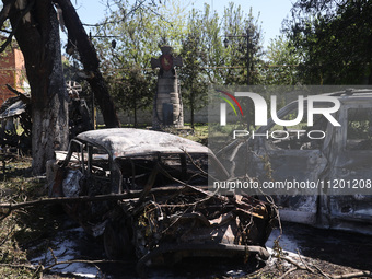 Burnt-out cars are being seen in the street following a Russian strike on Zolochiv in the Kharkiv region, northeastern Ukraine, with guided...