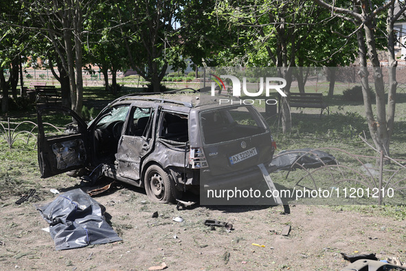 Human remains pouches containing the bodies of victims are lying on the ground next to a damaged car following a Russian strike in Zolochiv,...