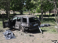 Human remains pouches containing the bodies of victims are lying on the ground next to a damaged car following a Russian strike in Zolochiv,...