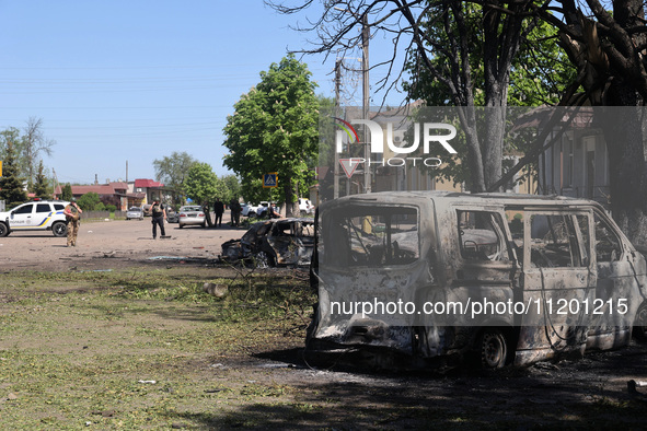 Burnt-out cars are being seen in the street following a Russian strike on Zolochiv in the Kharkiv region, northeastern Ukraine, with guided...