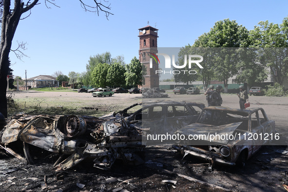 Burnt-out cars are being seen in the street following a Russian strike on Zolochiv in the Kharkiv region, northeastern Ukraine, with guided...