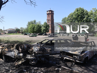 Burnt-out cars are being seen in the street following a Russian strike on Zolochiv in the Kharkiv region, northeastern Ukraine, with guided...