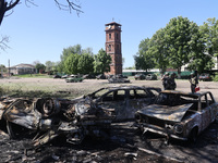 Burnt-out cars are being seen in the street following a Russian strike on Zolochiv in the Kharkiv region, northeastern Ukraine, with guided...