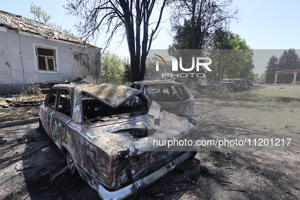 Burnt-out cars are being seen in the street following a Russian strike on Zolochiv in the Kharkiv region, northeastern Ukraine, with guided...