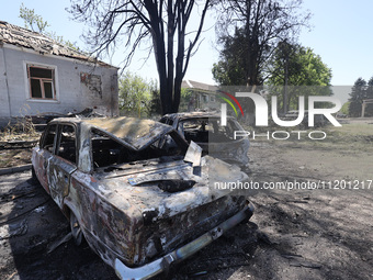 Burnt-out cars are being seen in the street following a Russian strike on Zolochiv in the Kharkiv region, northeastern Ukraine, with guided...