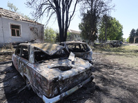 Burnt-out cars are being seen in the street following a Russian strike on Zolochiv in the Kharkiv region, northeastern Ukraine, with guided...