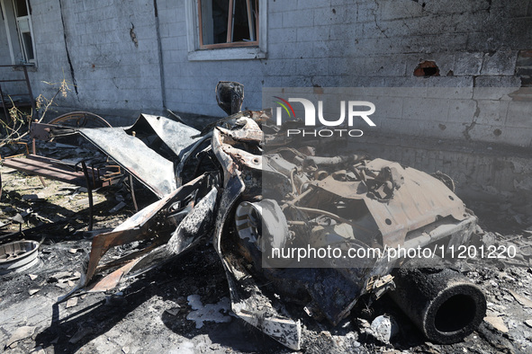 A burnt-out car is being seen in the street following a Russian strike on Zolochiv in the Kharkiv region, northeastern Ukraine, with guided...