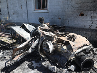 A burnt-out car is being seen in the street following a Russian strike on Zolochiv in the Kharkiv region, northeastern Ukraine, with guided...