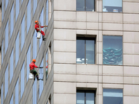 Workers are cleaning the windows on each floor of a high-rise building in the Chaoyang district of Beijing, China, on May 1, 2024. In Beijin...