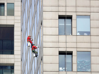 Workers are cleaning the windows on each floor of a high-rise building in the Chaoyang district of Beijing, China, on May 1, 2024. In Beijin...