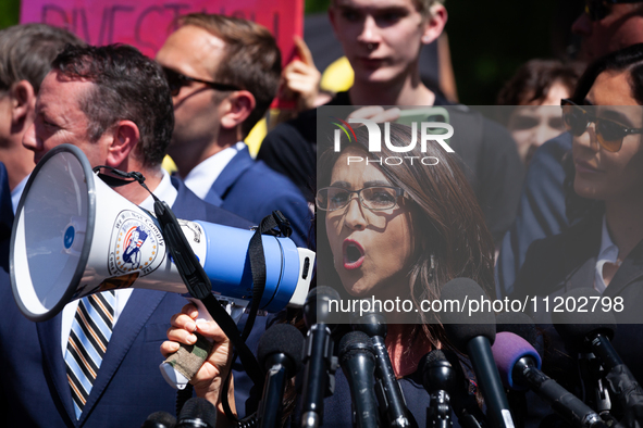 Rep. Lauren Boebert (R-CO) uses a bullhorn to be heard over the crowd noise during a press conference at the George Washington University Ga...