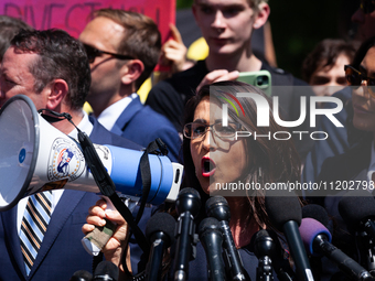 Rep. Lauren Boebert (R-CO) uses a bullhorn to be heard over the crowd noise during a press conference at the George Washington University Ga...