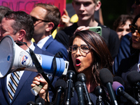 Rep. Lauren Boebert (R-CO) uses a bullhorn to be heard over the crowd noise during a press conference at the George Washington University Ga...