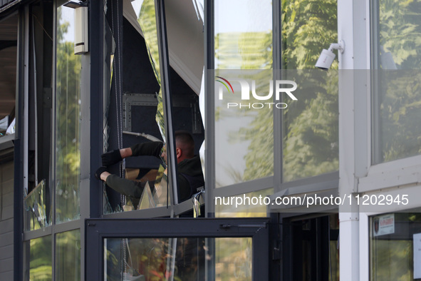 A man is clearing away glass shards at a Nova Poshta depot that was damaged by a Russian ballistic missile strike in Odesa, Ukraine, on May...