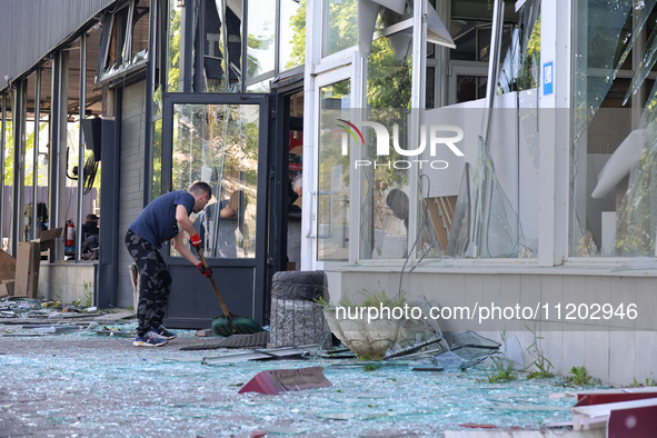 A man is clearing away glass shards at a Nova Poshta depot that was damaged by a Russian ballistic missile strike in Odesa, Ukraine, on May...