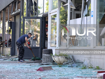 A man is clearing away glass shards at a Nova Poshta depot that was damaged by a Russian ballistic missile strike in Odesa, Ukraine, on May...