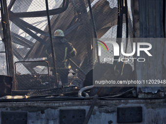 A firefighter is putting out a fire at a Nova Poshta depot and cargo branch in Odesa, Ukraine, on May 2, 2024, which was damaged by a Russia...