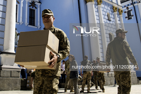 Ukrainian soldiers are loading boxes of Easter cakes at St. Michael's Cathedral in Kyiv, Ukraine, on May 2, 2024, after an Orthodox service....