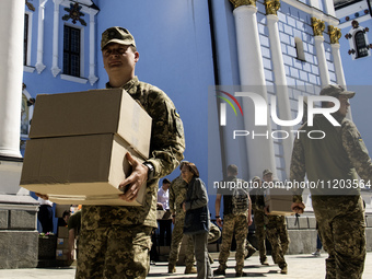 Ukrainian soldiers are loading boxes of Easter cakes at St. Michael's Cathedral in Kyiv, Ukraine, on May 2, 2024, after an Orthodox service....