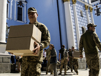 Ukrainian soldiers are loading boxes of Easter cakes at St. Michael's Cathedral in Kyiv, Ukraine, on May 2, 2024, after an Orthodox service....