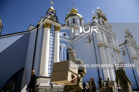 Ukrainian soldiers are loading boxes of Easter cakes at St. Michael's Cathedral in Kyiv, Ukraine, on May 2, 2024, after an Orthodox service....