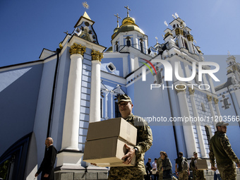 Ukrainian soldiers are loading boxes of Easter cakes at St. Michael's Cathedral in Kyiv, Ukraine, on May 2, 2024, after an Orthodox service....