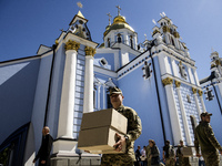 Ukrainian soldiers are loading boxes of Easter cakes at St. Michael's Cathedral in Kyiv, Ukraine, on May 2, 2024, after an Orthodox service....