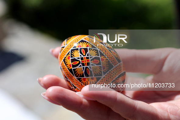 A woman is holding a Ukrainian Easter egg, known as the pysanka, in Rynok Square ahead of Orthodox Easter on May 5, in Ivano-Frankivsk, Ukra...