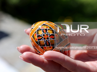 A woman is holding a Ukrainian Easter egg, known as the pysanka, in Rynok Square ahead of Orthodox Easter on May 5, in Ivano-Frankivsk, Ukra...