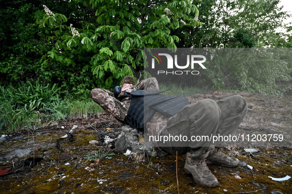 A serviceman from the Steppe Wolves all-volunteer unit is lying down in the Zaporizhzhia Region, southeastern Ukraine, on April 27, 2024. 