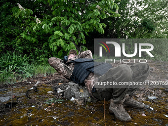 A serviceman from the Steppe Wolves all-volunteer unit is lying down in the Zaporizhzhia Region, southeastern Ukraine, on April 27, 2024. (