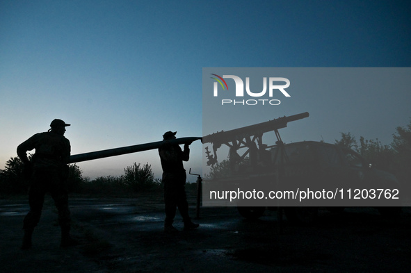 Servicemen of the Steppe Wolves all-volunteer unit are loading Grad rocket launch tubes that they captured from Russian troops and a sightin...