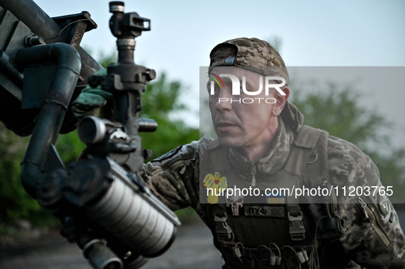 A serviceman from the Steppe Wolves all-volunteer unit is looking through a sighting device installed on Grad rocket launch tubes, which wer...