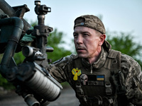 A serviceman from the Steppe Wolves all-volunteer unit is looking through a sighting device installed on Grad rocket launch tubes, which wer...