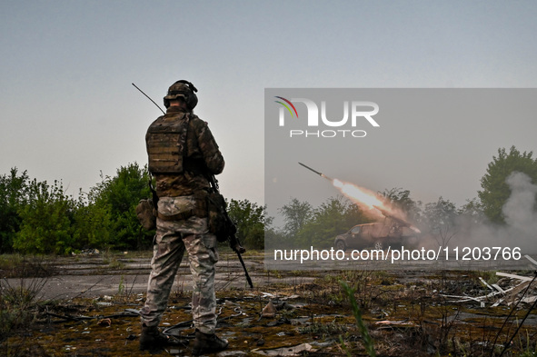 A serviceman from the Steppe Wolves all-volunteer unit is standing near a pickup equipped with Grad rocket launch tubes, which were captured...